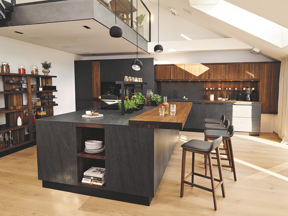 Eine Massivholzküche im dunklen Design mit Kücheninsel, Barhockern und Einbauschränken.